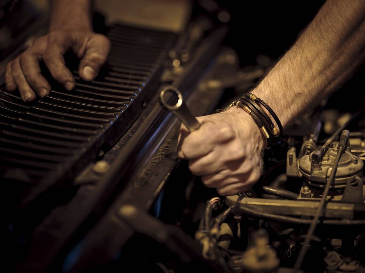 Yağlı ellerle motor üzerinde anahtar kullanımı